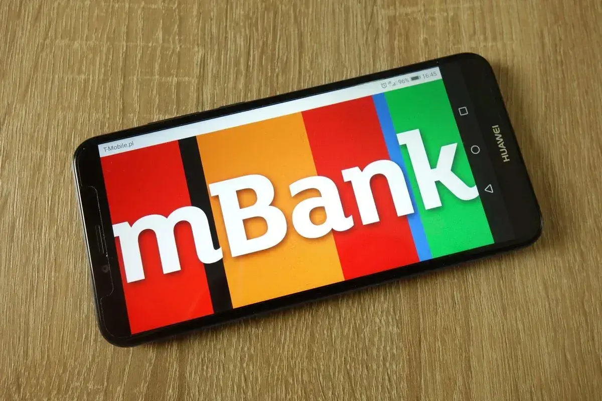 Smartfon z logo mBank na ekranie. Dowiedz się, jak aktywować kartę w aplikacji bankowej.