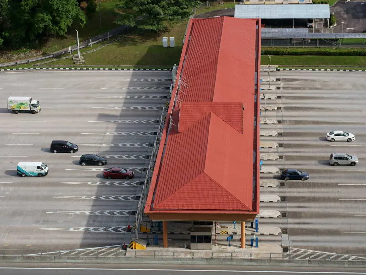 Vue aérienne d'une station de péage avec plusieurs voitures et un camion. Attention à ne pas recevoir d'amende péage en payant votre passage.