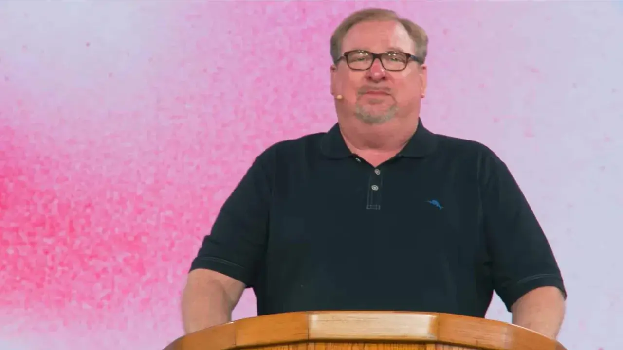 Rick Warren, mit Brille und Bart, spricht hinter einem Holzpult. Der Hintergrund ist pink.