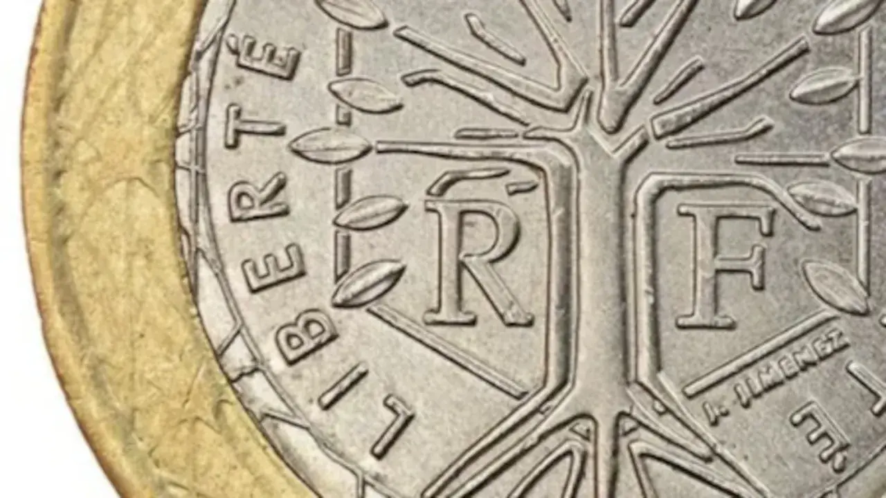Detalle de una moneda de la República Francesa con un árbol estilizado y las letras "R" y "F".