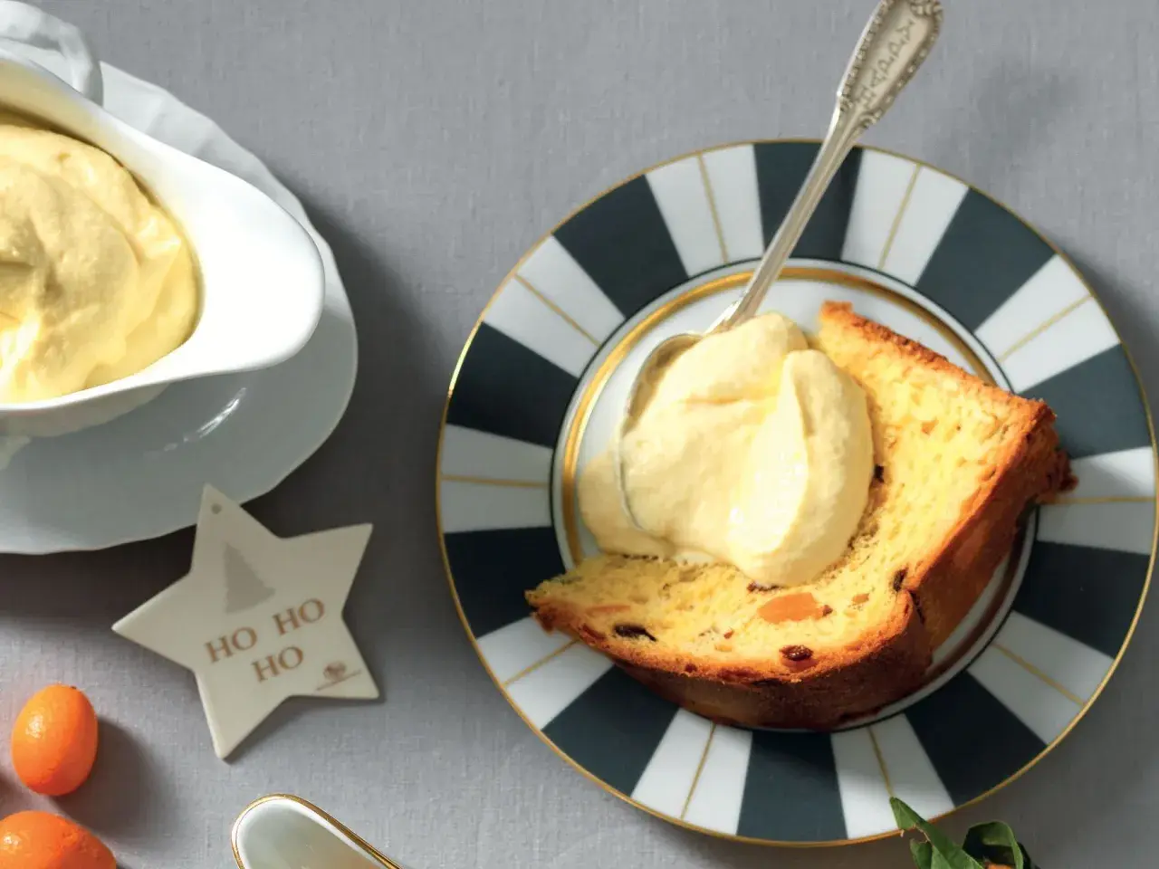 Una fetta di panettone con abbondante crema al mascarpone, servita su un piatto decorato. Un'idea golosa per le feste.