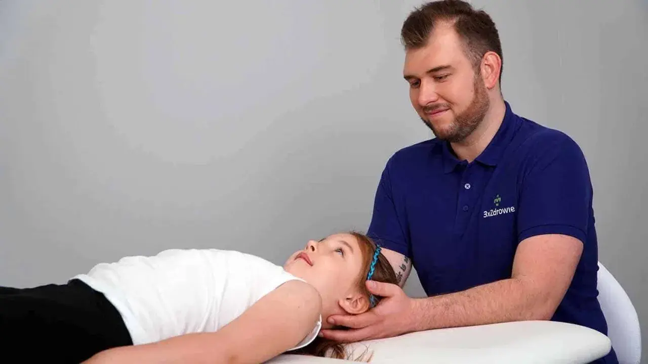 Terapia czaszkowo-krzyżowa pomaga dziecku z depresją. Terapeuta delikatnie dotyka głowy dziewczynki.