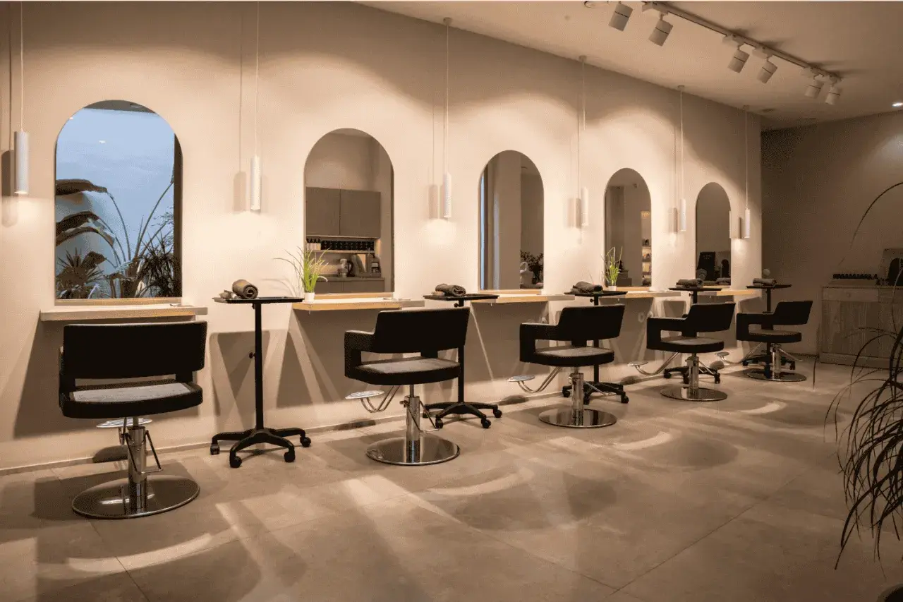 Estilo moderno en peluquería. Sillones negros, espejos arqueados y plantas. Descubre los secretos de agua peluquería para un look radiante.