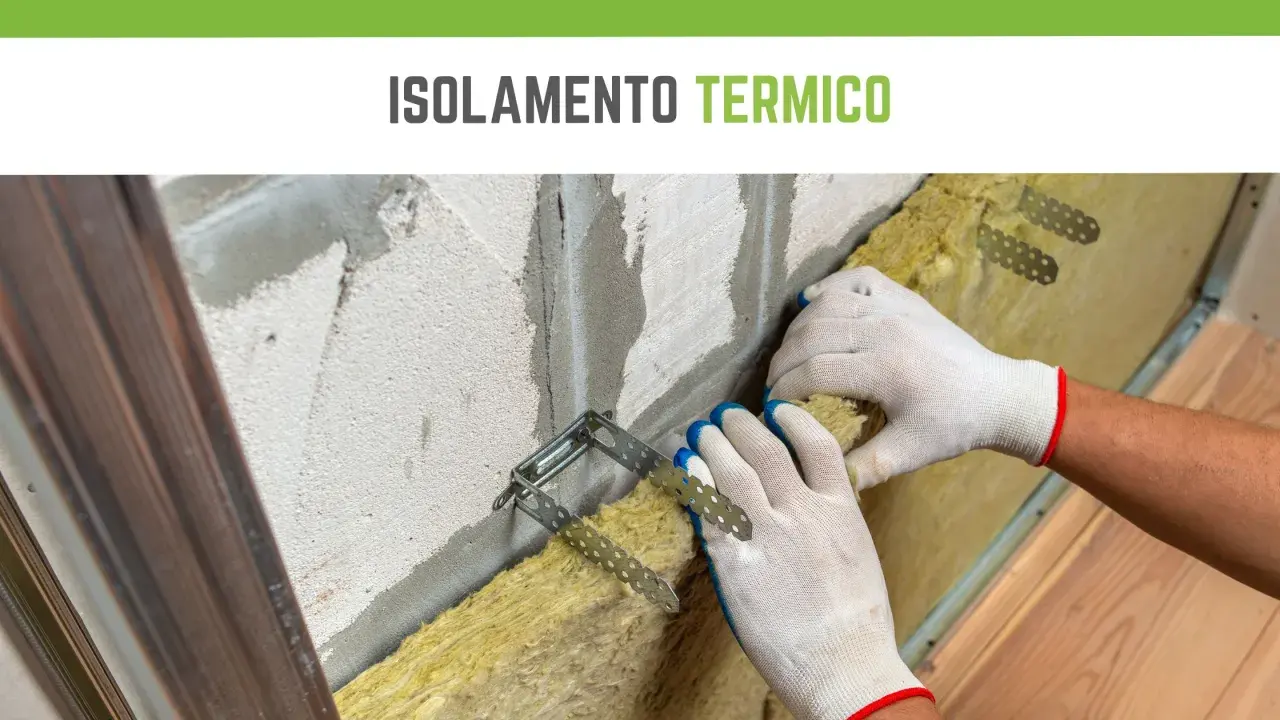 Mani guantate installano materiale isolante termico in lana di roccia su una parete grezza, fissato con staffe metalliche.