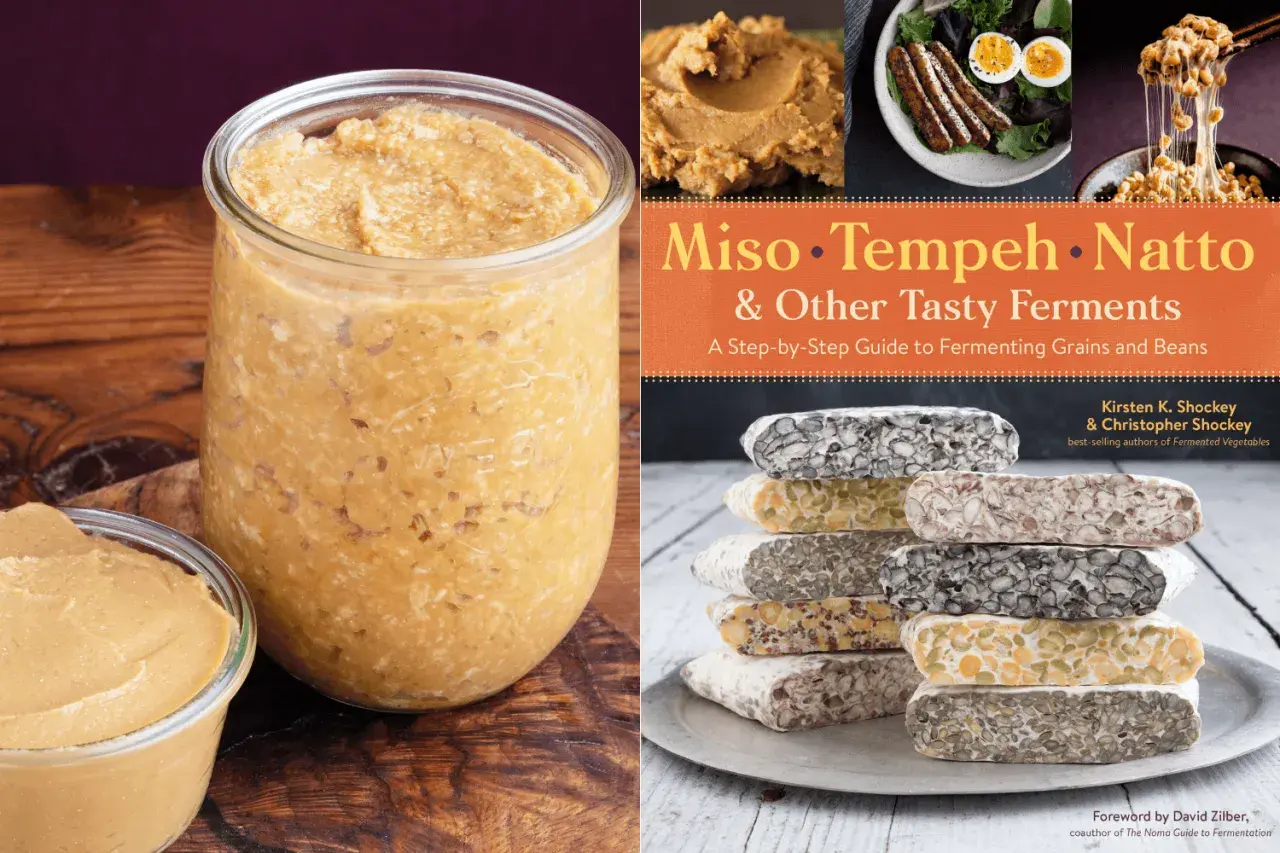 A jar of homemade miso paste next to a cookbook titled "Miso, Tempeh, Natto & Other Tasty Ferments," showcasing a variety of fermented foods.