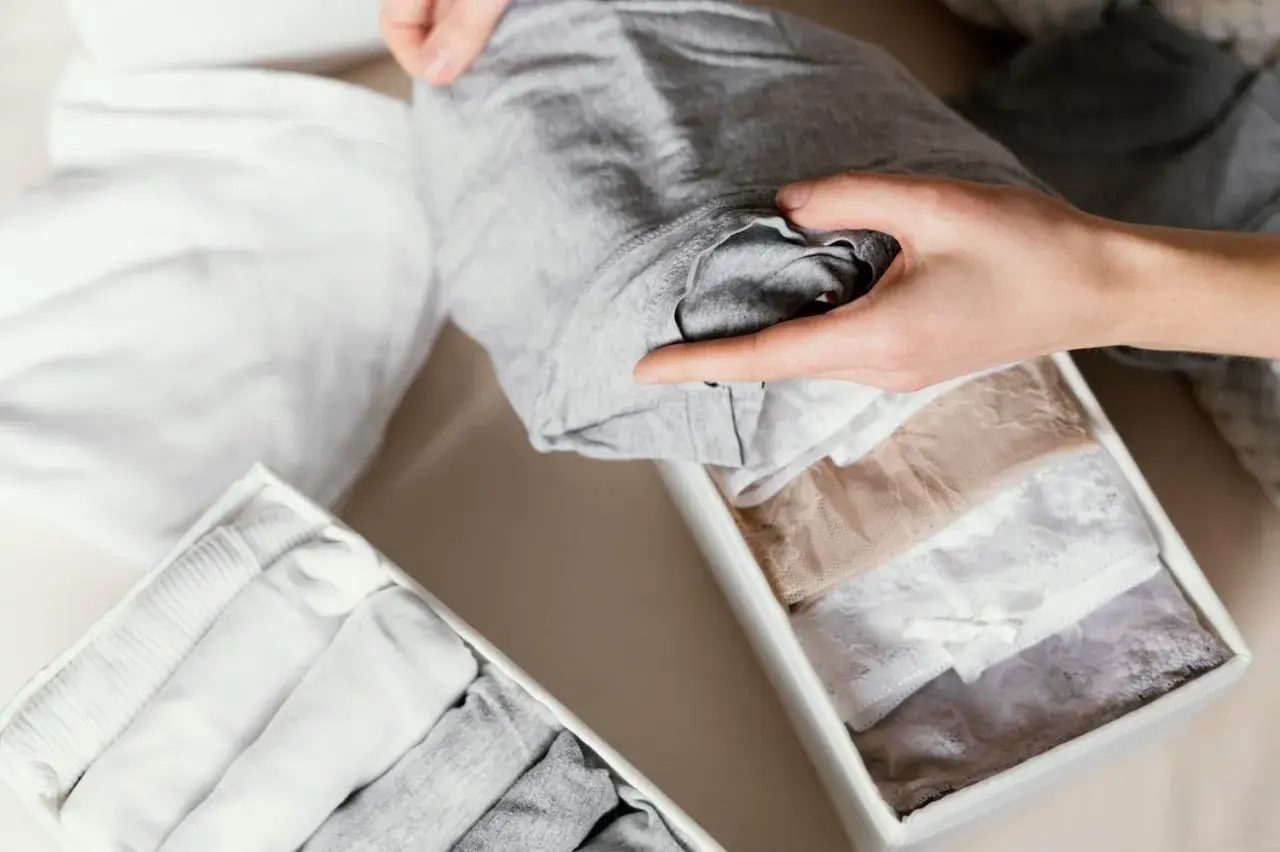 Mains pliant des sous-vêtements en tissu synthétique. Organisation de tiroirs pour blanchir et ranger.