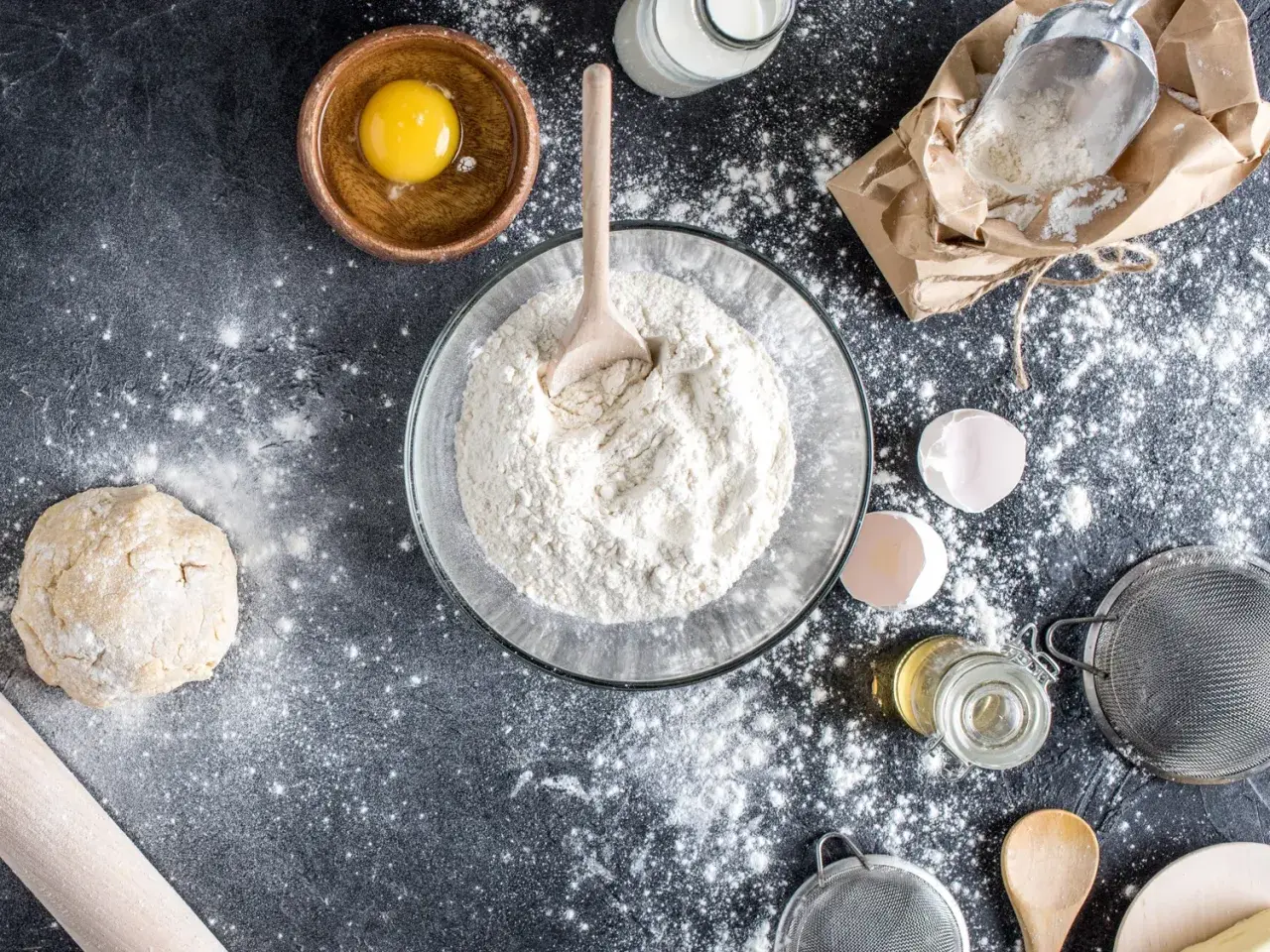 Préparation d'une recette avec de la farine T80, c'est quoi ? Œuf, pâte, lait, huile, tamis, tout est prêt pour le pain.