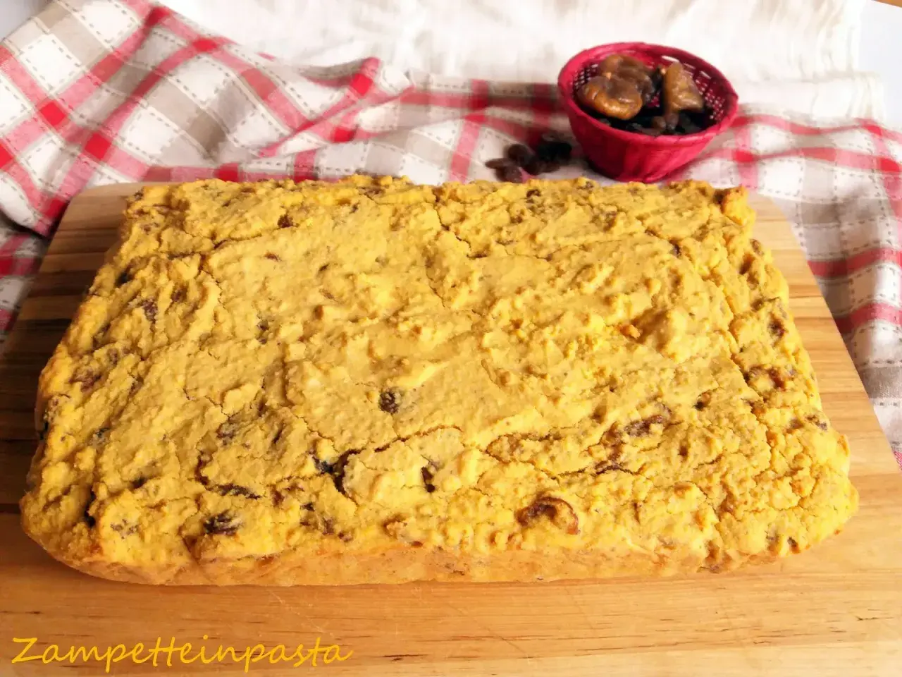 Pincia veneziana, dolce tipico natalizio, con uvetta e fichi secchi, su tagliere di legno.