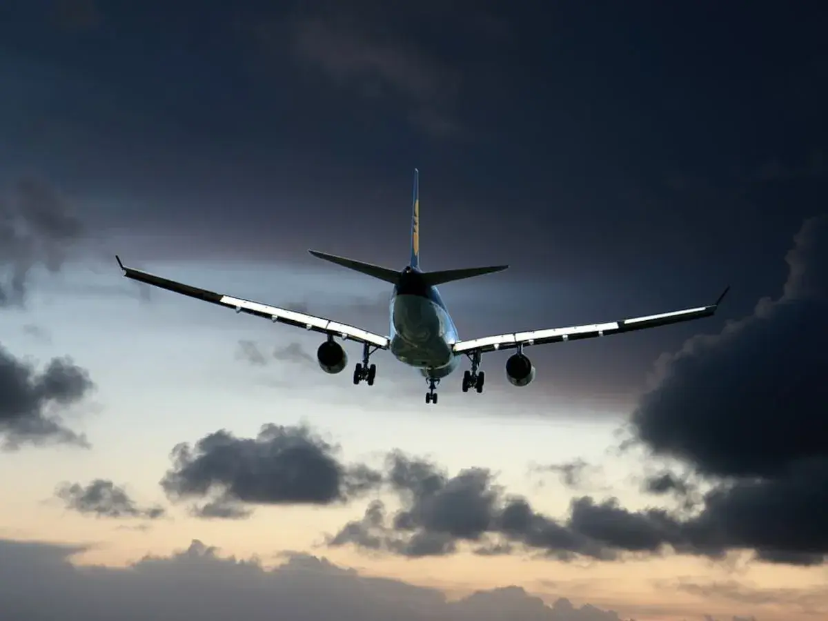Avión descendiendo entre nubes oscuras, como si fuera un mal sueño.