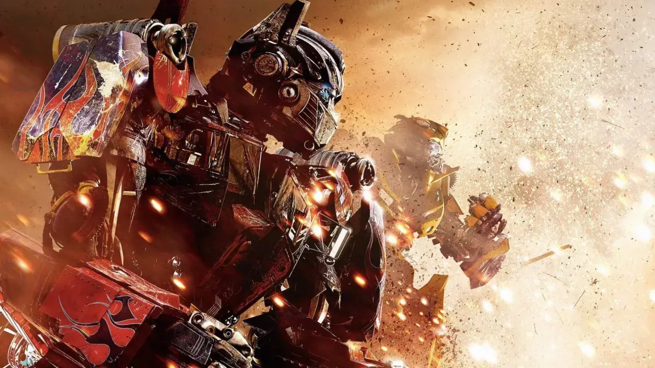 Optimus Prime i Bumblebee w akcji. W tle eksplozje i pył. Widać szczegółowe transformers części.
