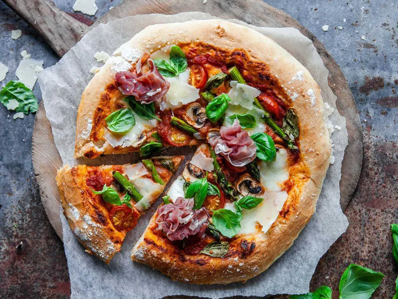 En härlig italiensk pizza med sparris, parmaskinka, champinjoner och färsk basilika.