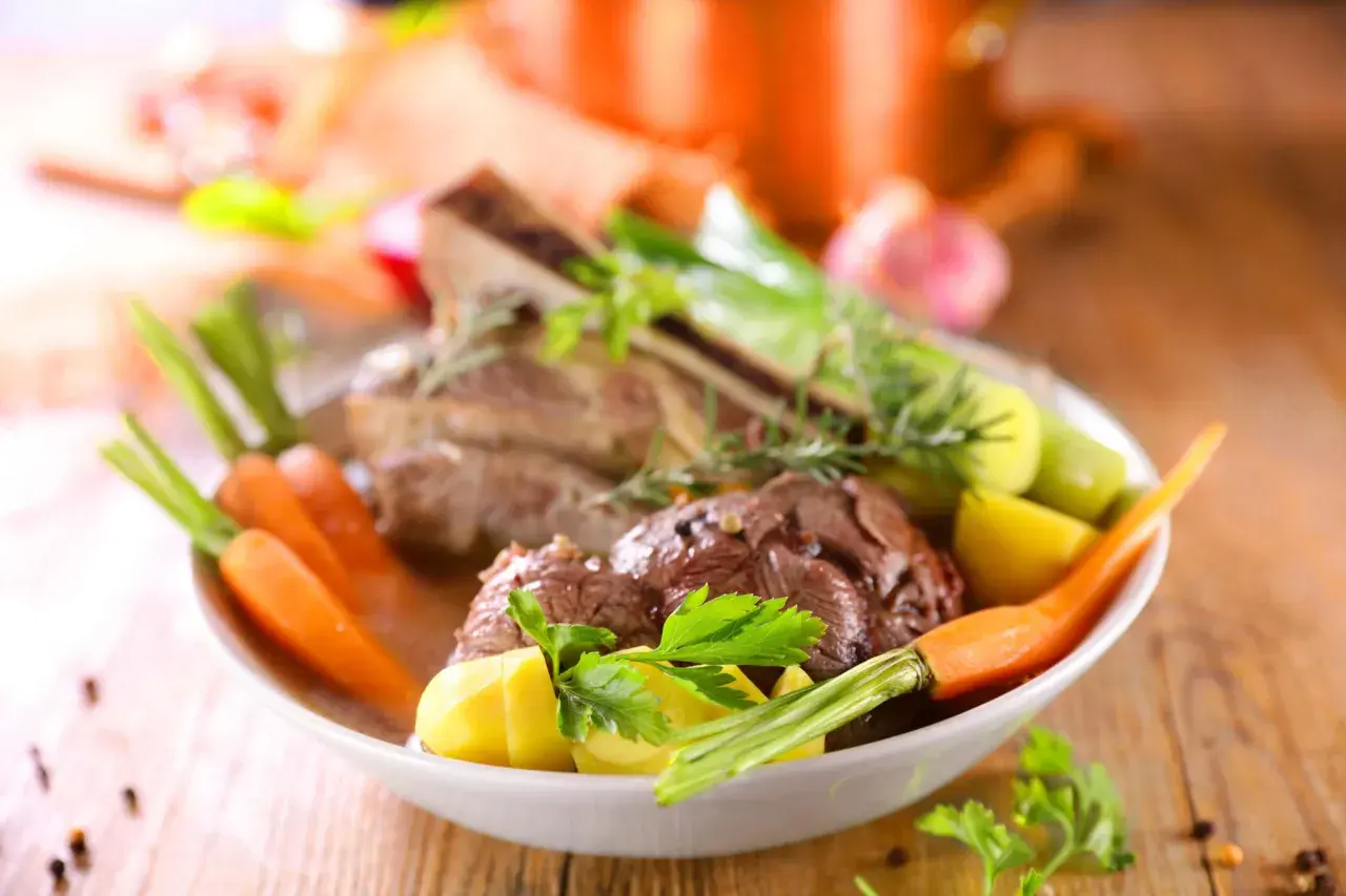 Un plat réconfortant de pot-au-feu, avec du bœuf tendre, des carottes, des pommes de terre et des poireaux, garni de persil frais.