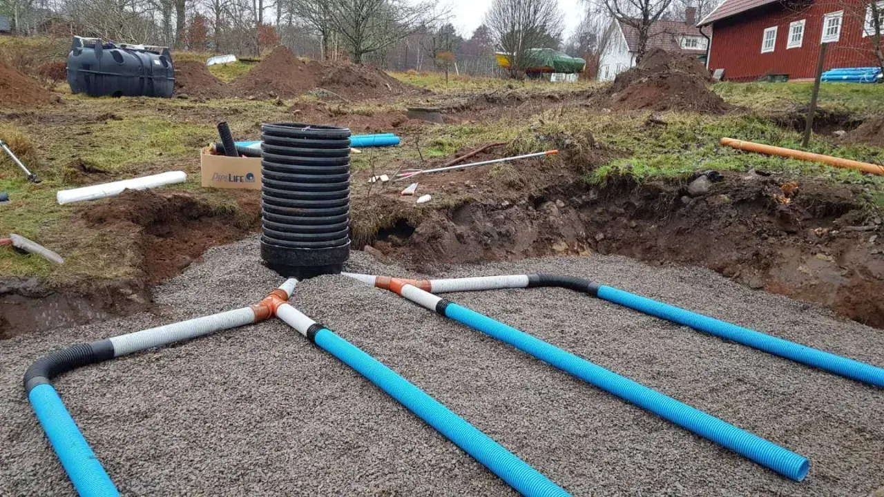 Arbetet med enskilt avlopp pågår. Grus och rör läggs ut för att hantera avloppsvatten, en viktig investering för framtiden.
