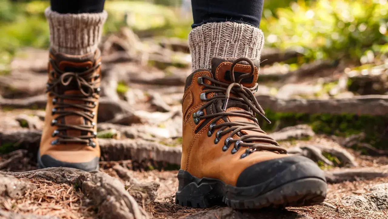 Brown leather hiking boots with thick socks, ready for the trail. Proper wanderschuhe pflegen ensures many adventures.