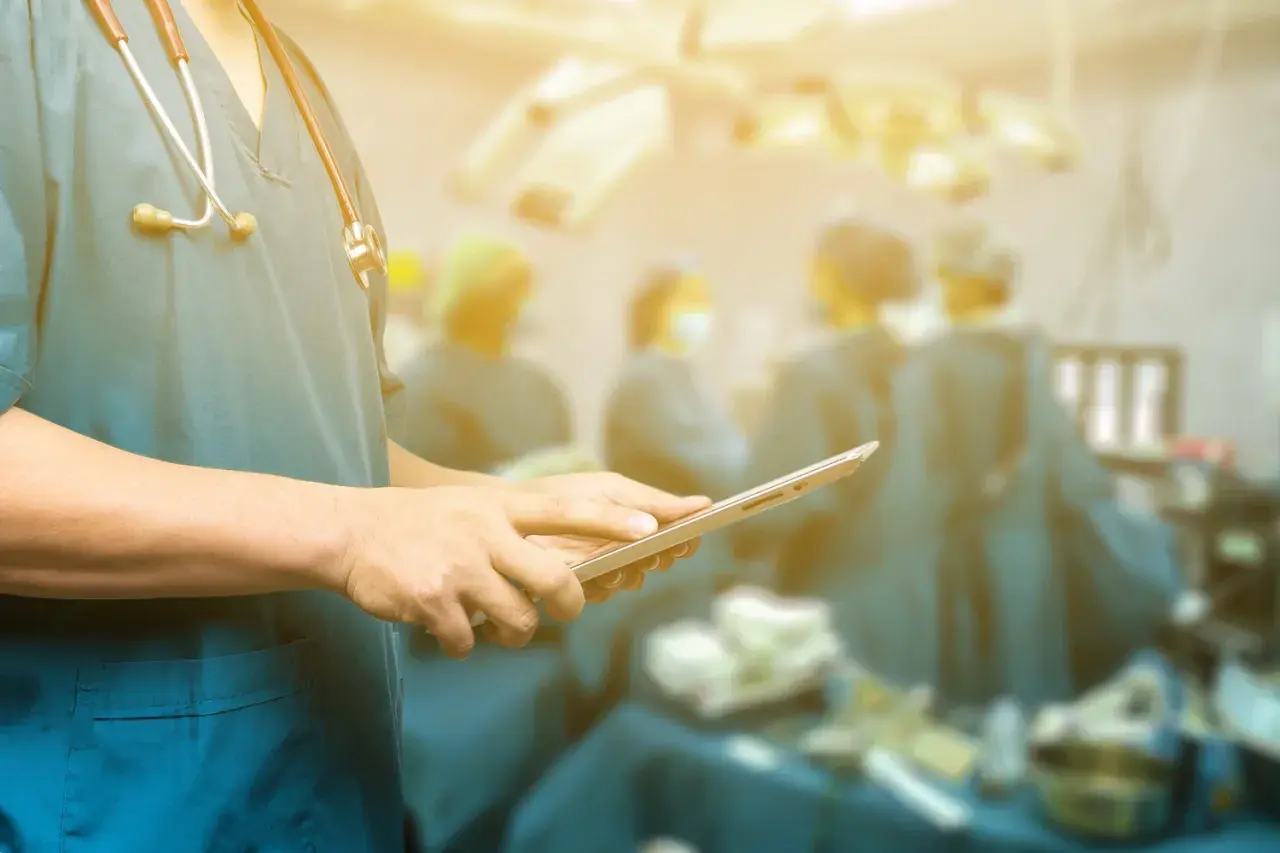 Medico con stetoscopio e tablet in sala operatoria. In caso di errori medici a chi rivolgersi per assistenza.