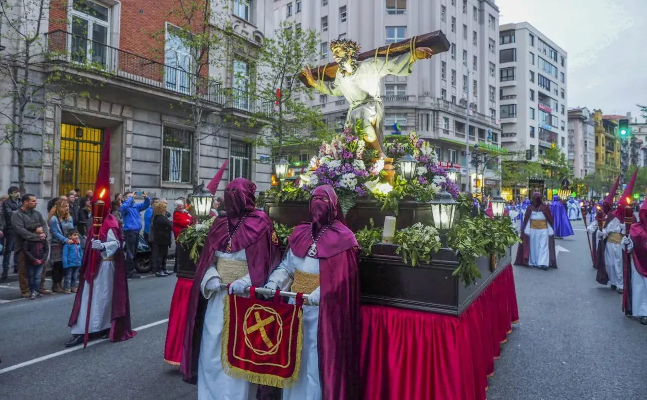 Procesiones Semana Santa Santander: figuras religiosas y nazarenos desfilan por la calle.