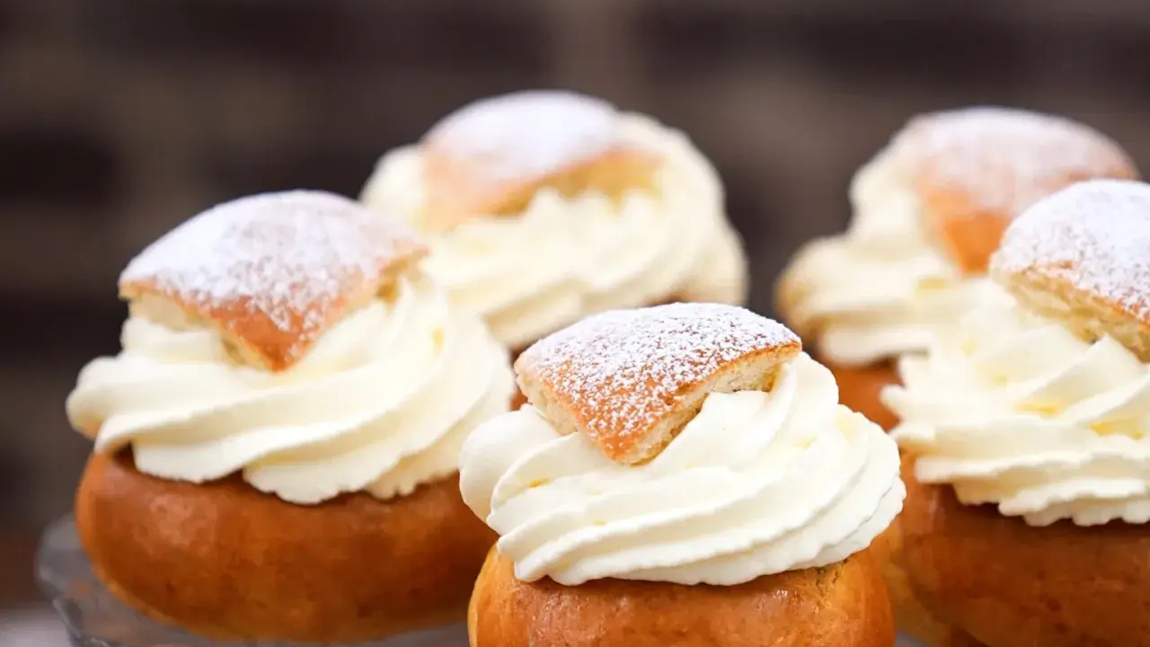 Fem fluffiga semlor med rikligt vispad grädde och pudrat florsocker. Perfekt för att baka egna semlor till fikat.