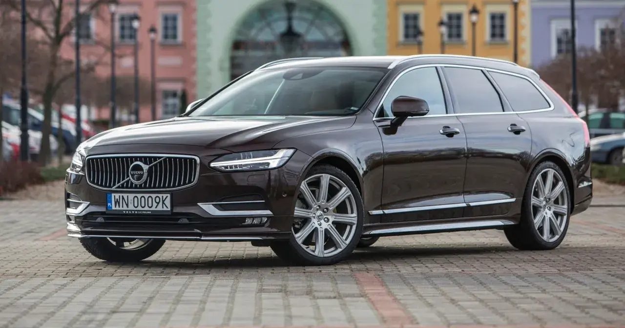 Brązowe Volvo V90 na tle kamienic. Sprawdź akcje serwisowe Volvo po VIN, aby upewnić się, że Twój samochód jest bezpieczny.