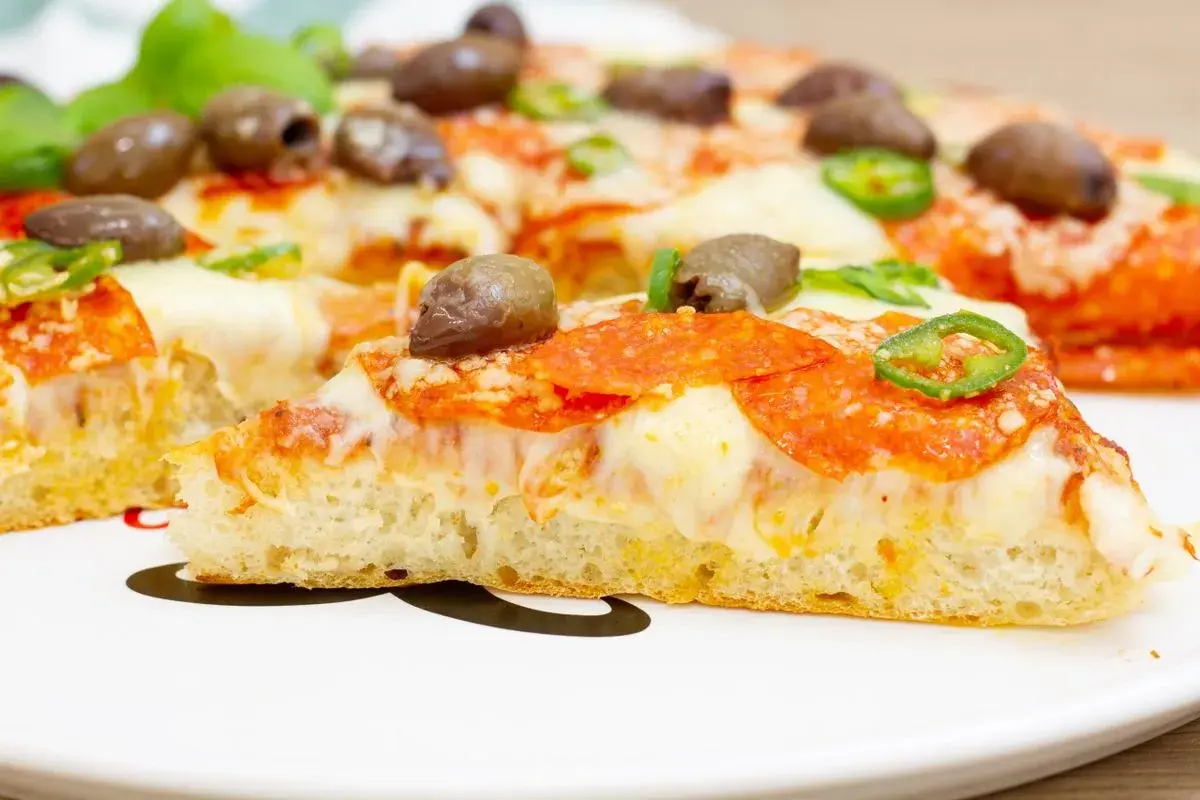 Pyszna pizza z patelni z pikantnym salami, oliwkami i papryczką jalapeno. Idealna na szybki obiad.