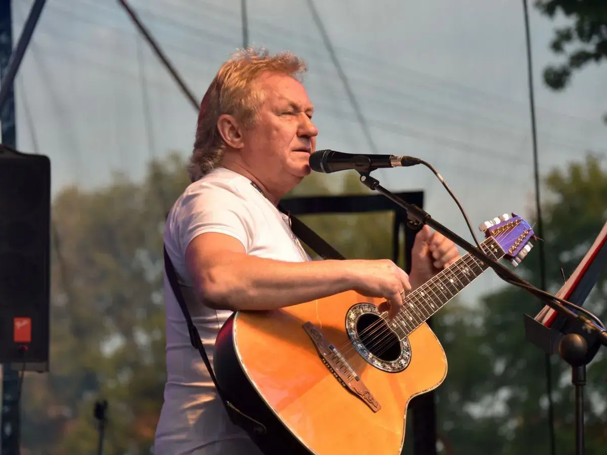 Janusz Laskowski śpiewa i gra na gitarze podczas kolorowych jarmarków.