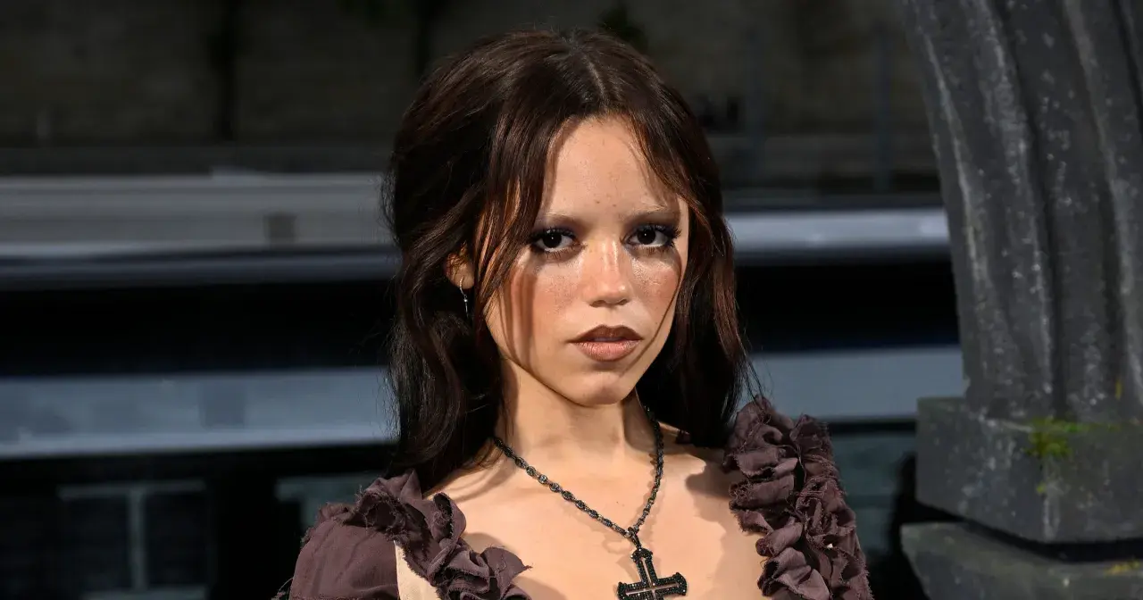 Jenna Ortega, znana z roli Wednesday, ma 160 cm wzrostu. Na zdjęciu ma ciemne włosy i krzyż na szyi.