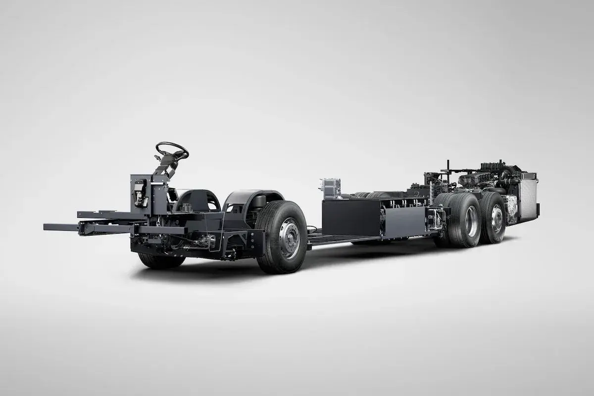 Châssis d'un bus Scania hybride, prêt à être assemblé, avec son volant et ses roues visibles.