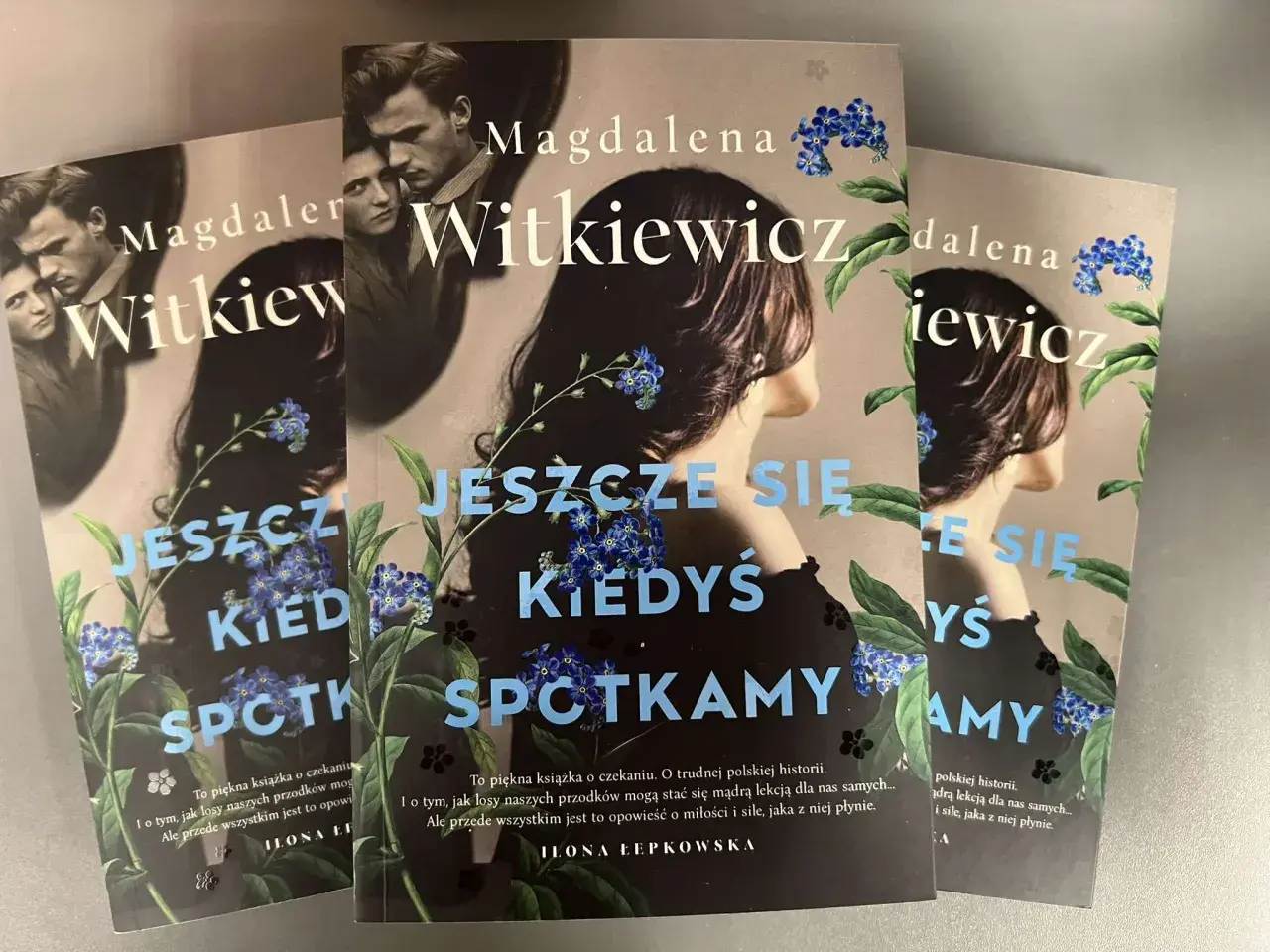 Okładki książek Magdaleny Witkiewicz "Jeszcze się kiedyś spotkamy" z motywem niezapominajek.