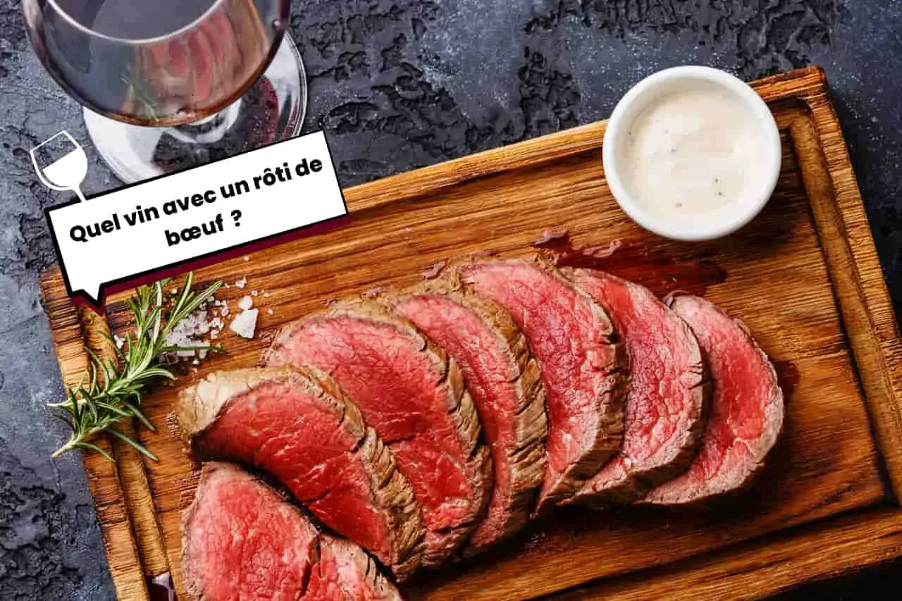 Un verre de vin rouge accompagne un rôti de bœuf tranché, prêt à être dégusté. Une question se pose : quel vin choisir pour ce plat savoureux ?