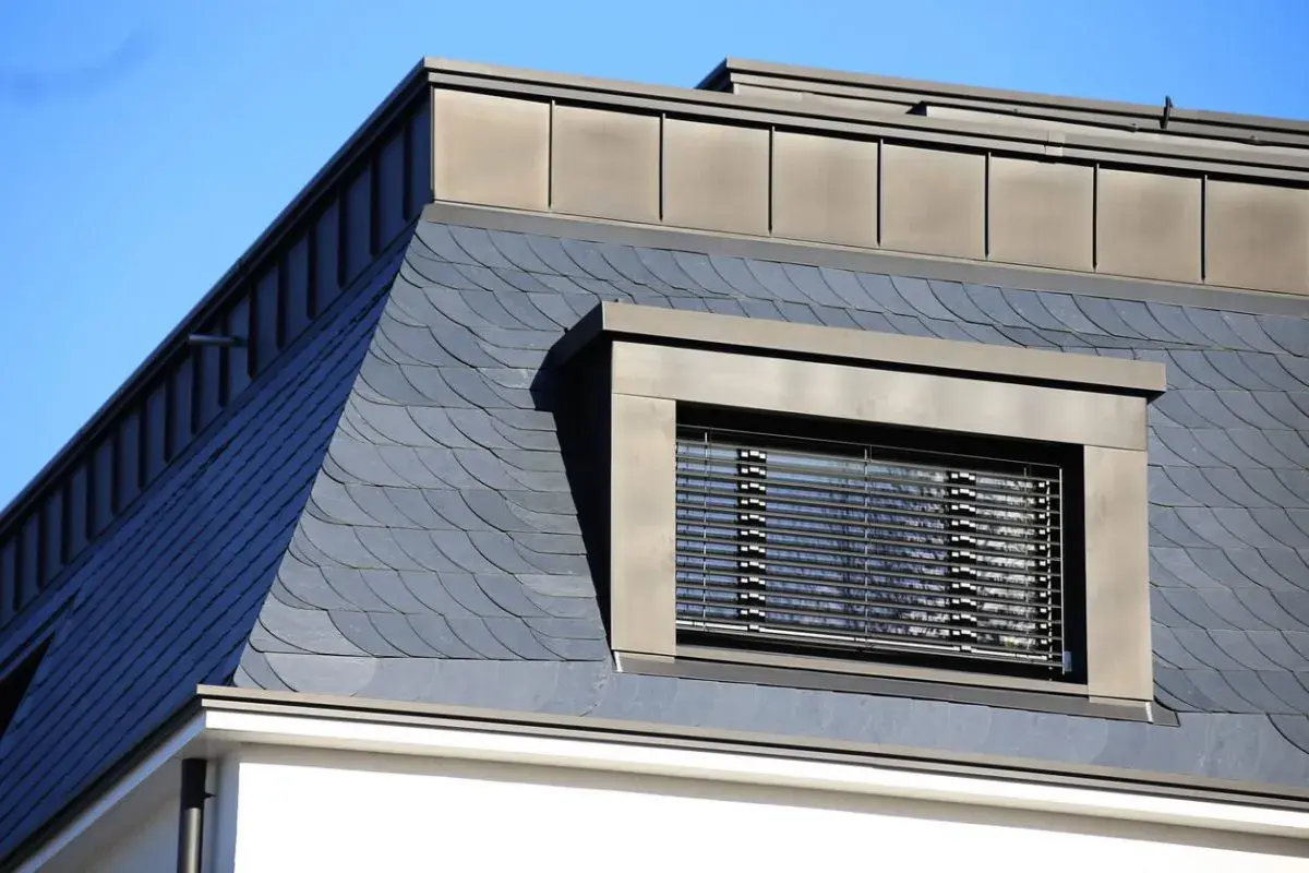 Schieferdeckung mit Fischschuppenmuster, ein Fenster mit Jalousien und ein Metalldach. Verschiedene verlegemuster schiefer deckungsarten.