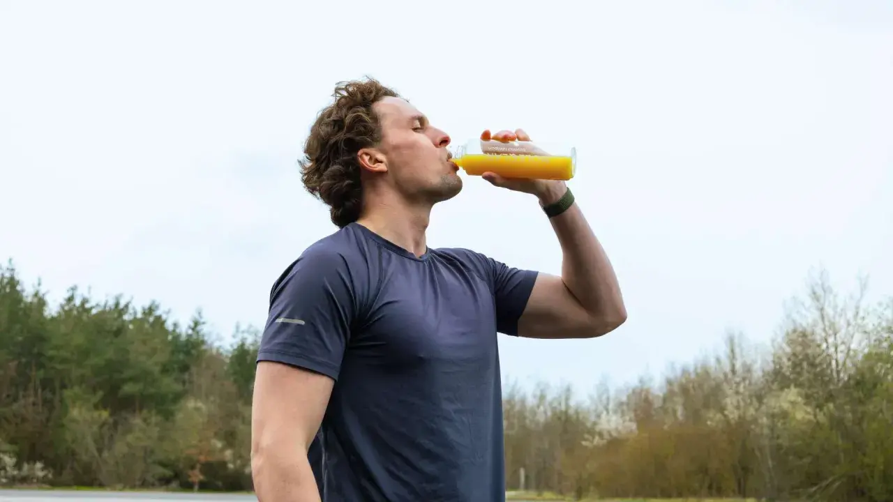 Sportler trinkt nach dem Training ein Getränk. Wann Elektrolyte nehmen? Nach dem Sport ist die beste Zeit.