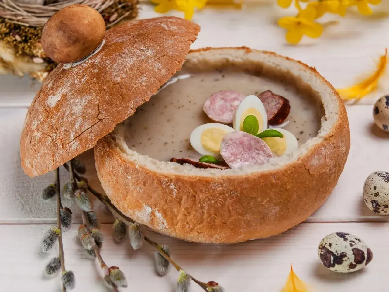 Zupa biały barszcz w chlebie, ozdobiona jajkiem i kiełbasą. Idealna, gdy zastanawiasz się, jak odkwasić zupę.