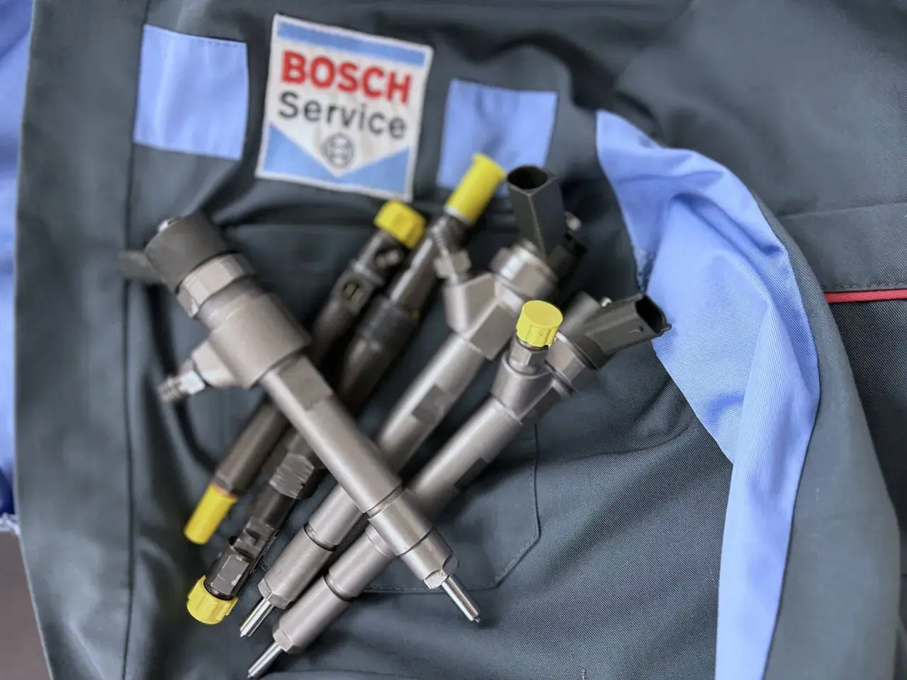 Wtryskiwacze diesla na tle logo Bosch Service. To gwarancja, że korekta wtrysku na plus jest w dobrych rękach.