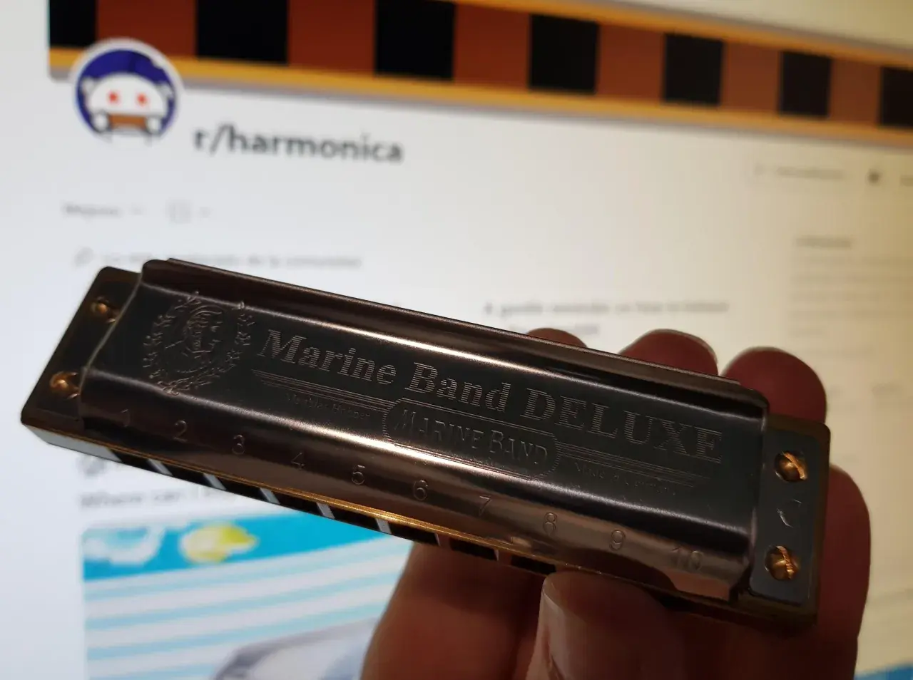 Harmonijka Marine Band DELUXE, z wygrawerowanymi nutami i numerami, gotowa do zagrania melodii.