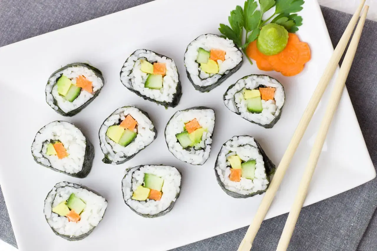 Talerz sushi z awokado, ogórkiem i marchewką. Czy sushi jest kaloryczne? Zależy od składników, ale te warzywne rolki wyglądają lekko!