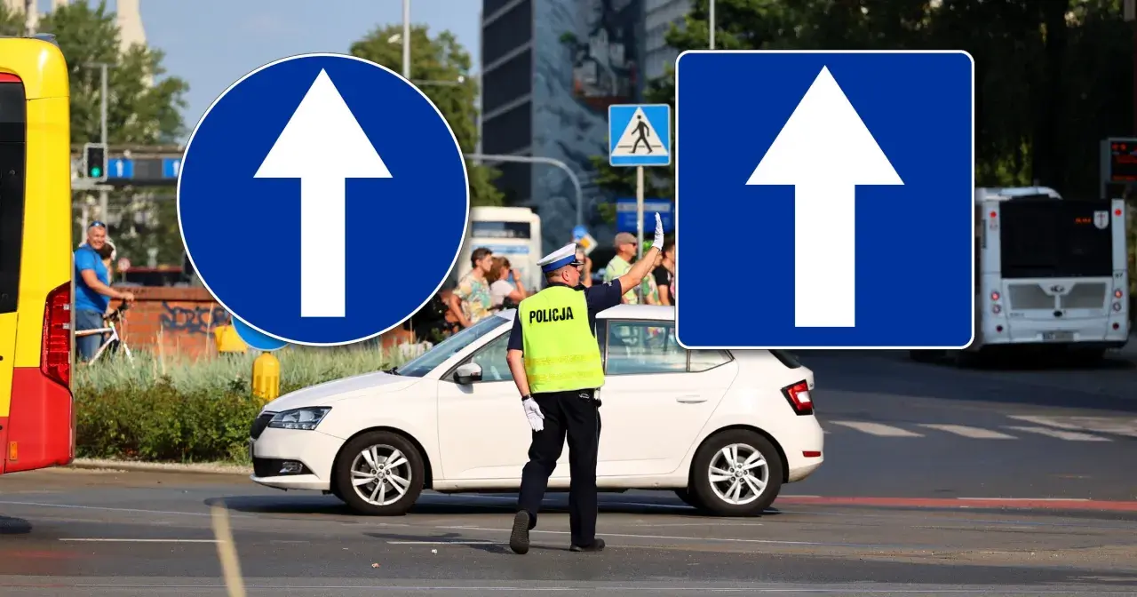 Policjant kieruje ruchem pod znakiem droga jednokierunkowa. Biała strzałka na niebieskim tle informuje o kierunku jazdy.