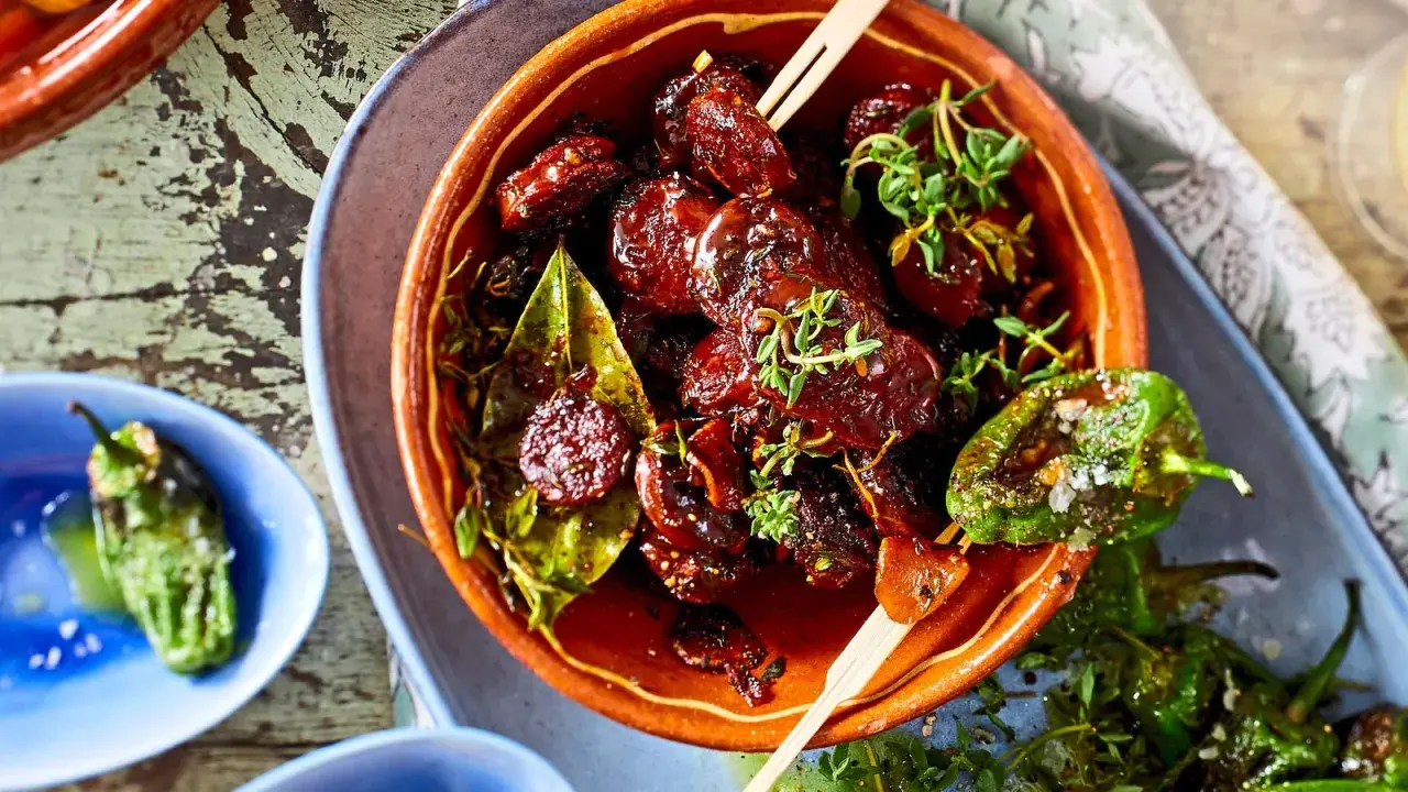 Leckeres Tapas Fingerfood: Glasierte Datteln mit Kräutern und geröstete Pimientos de Padrón.