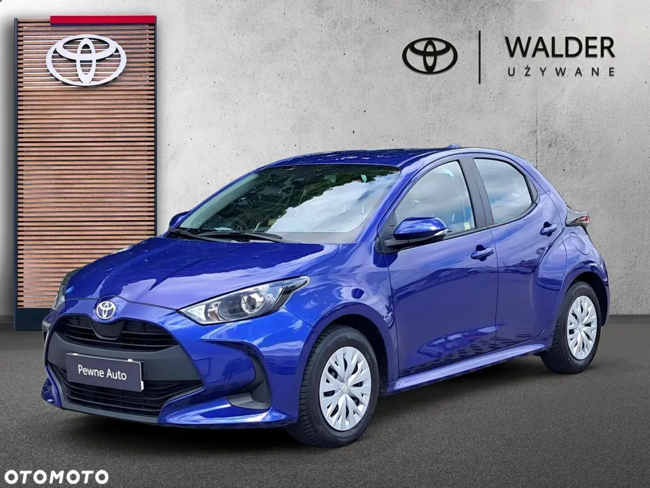 Niebieska Toyota Yaris przed salonem Walder Używane. Zastanawiasz się, ile kosztuje wymiana łożyska w Toyocie Yaris?