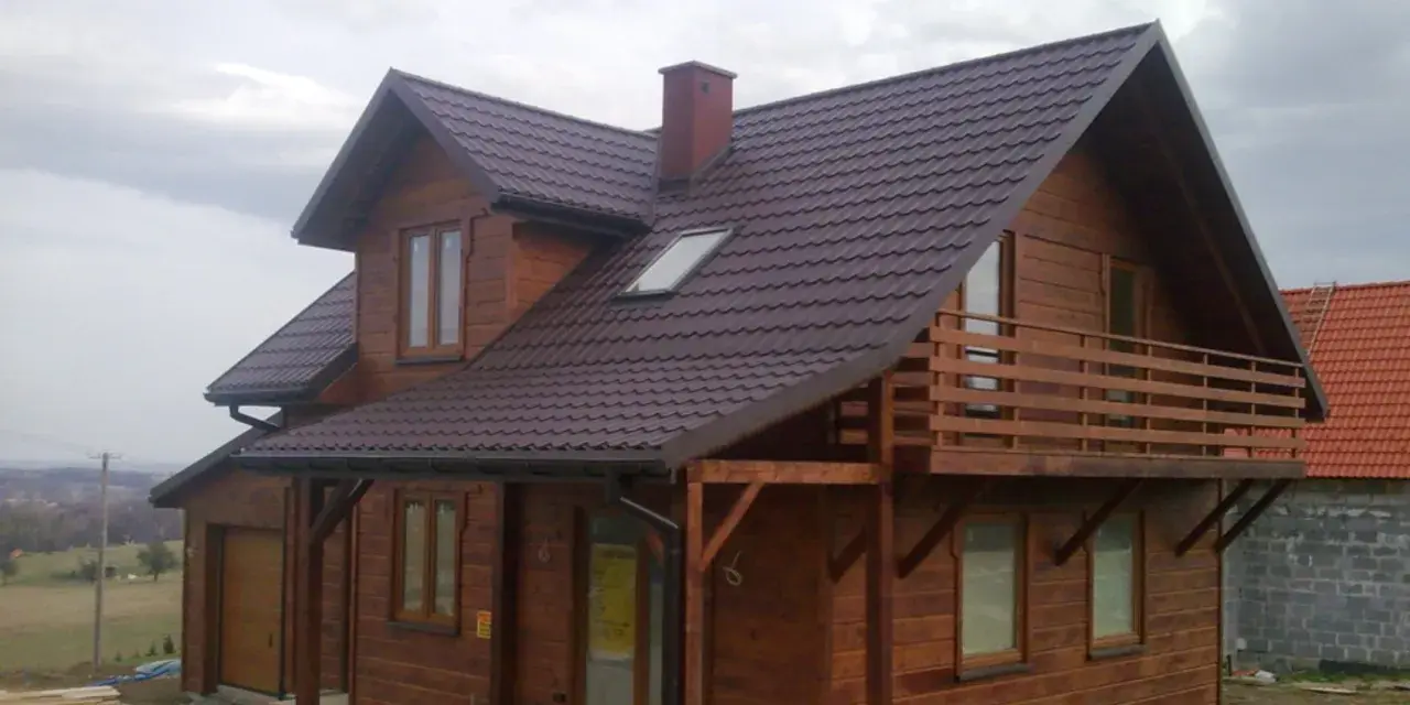 Drewniany dom pod klucz, gotowy do zamieszkania. Piękna, brązowa dachówka i przestronny balkon.