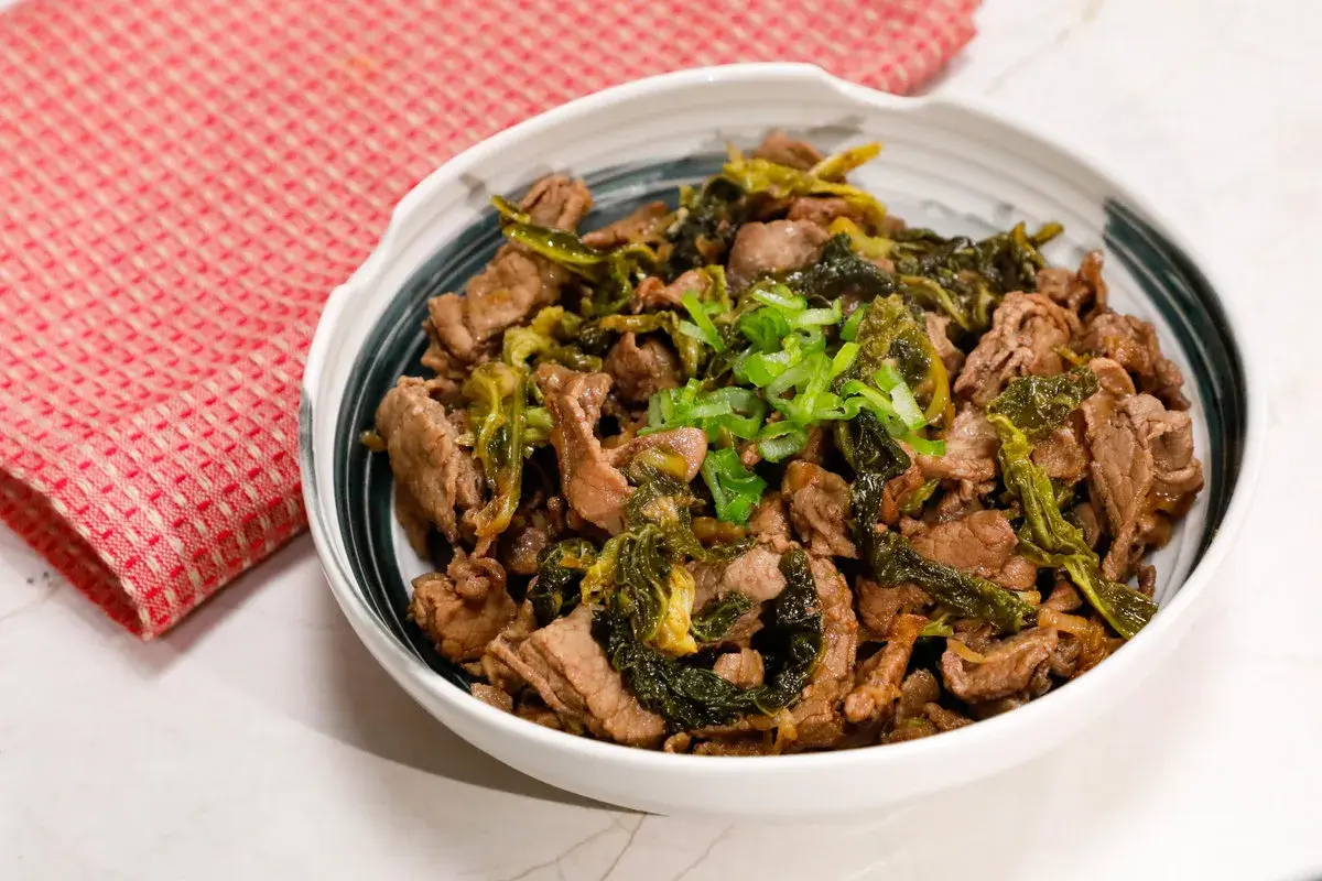 Straccetti di manzo saltati con verdure verdi e guarniti con cipollotto fresco. Un piatto saporito e invitante.