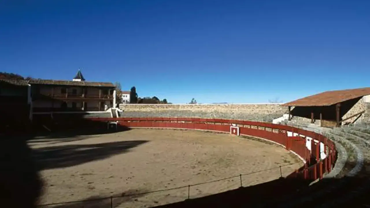 La plaza de toros de Las Ventas, la primera plaza de toros de España, con su ruedo de arena y gradas de piedra bajo un cielo azul.