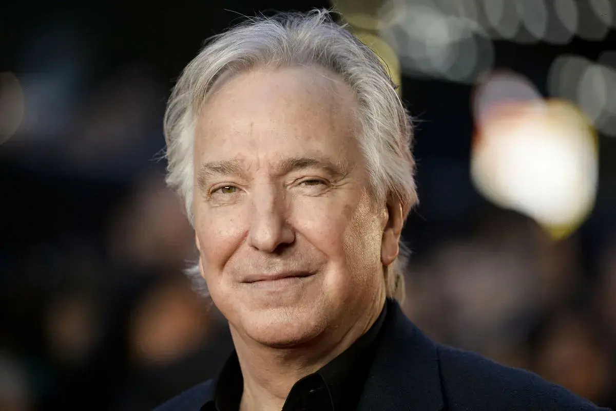 Uśmiechnięty Alan Rickman, z siwymi włosami, jakby właśnie skończył czytać fascynującą książkę.