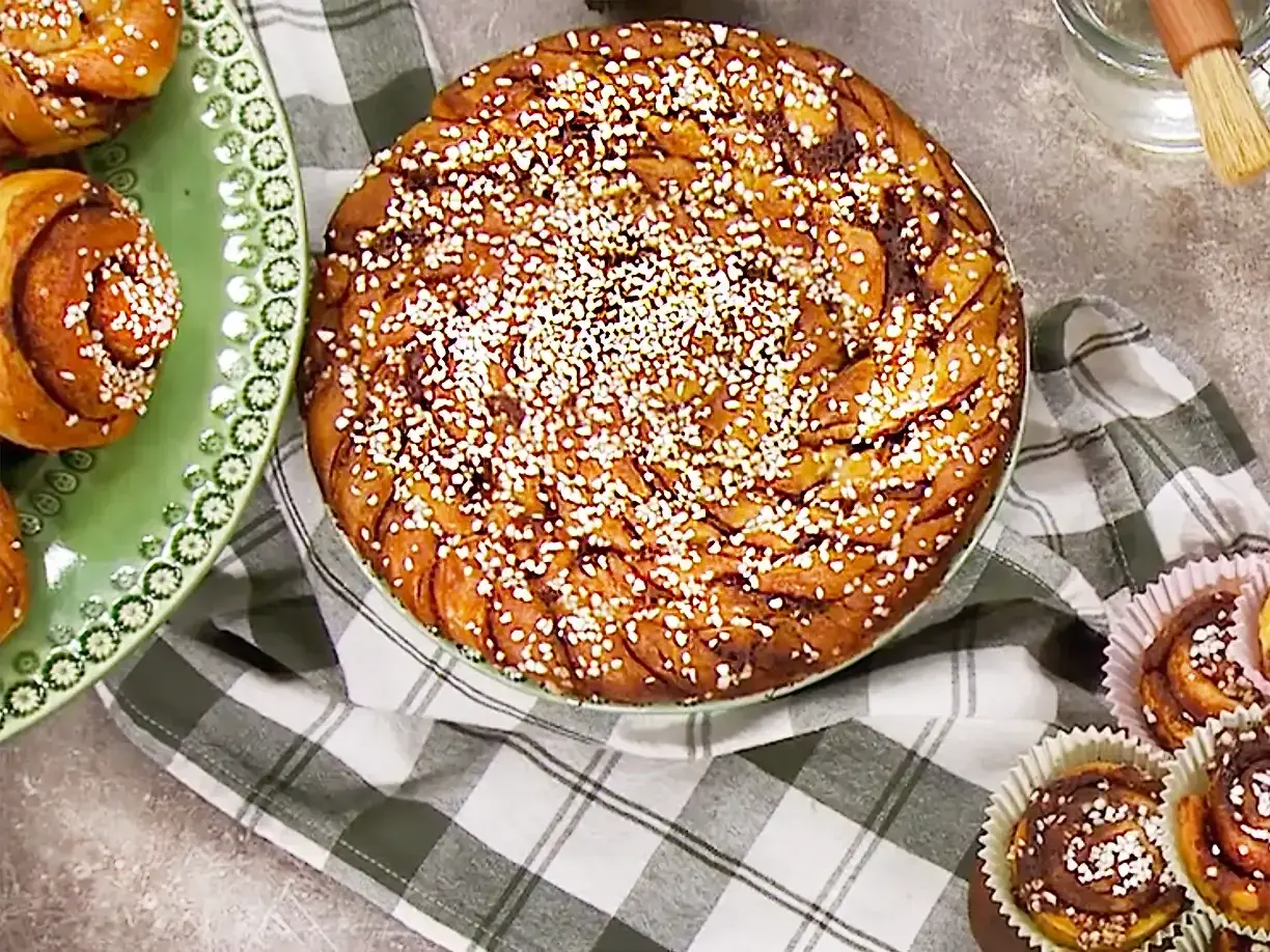 En stor kanelbulle och flera mindre bullar på bakpulver, redo att avnjutas.