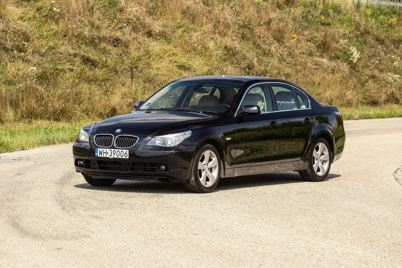 Czarne BMW 535d na tle zielonego wzgórza, gotowe na podróż.