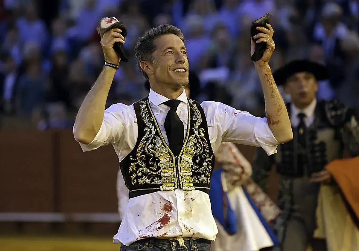 Manuel Escribano, triunfador, levanta las orejas del toro en la plaza.