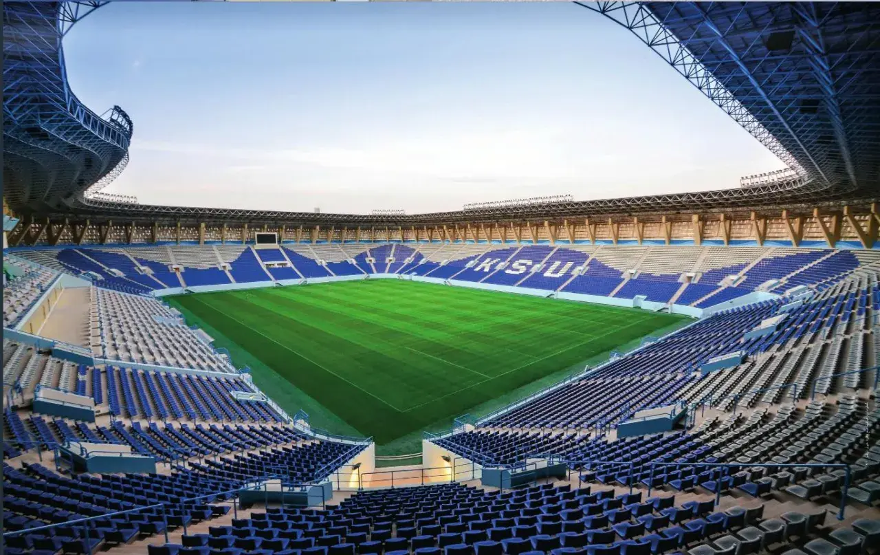 Puste trybuny stadionu Al Nassr czekają na kibiców. Zielona murawa lśni w słońcu, gotowa na emocjonujące mecze.