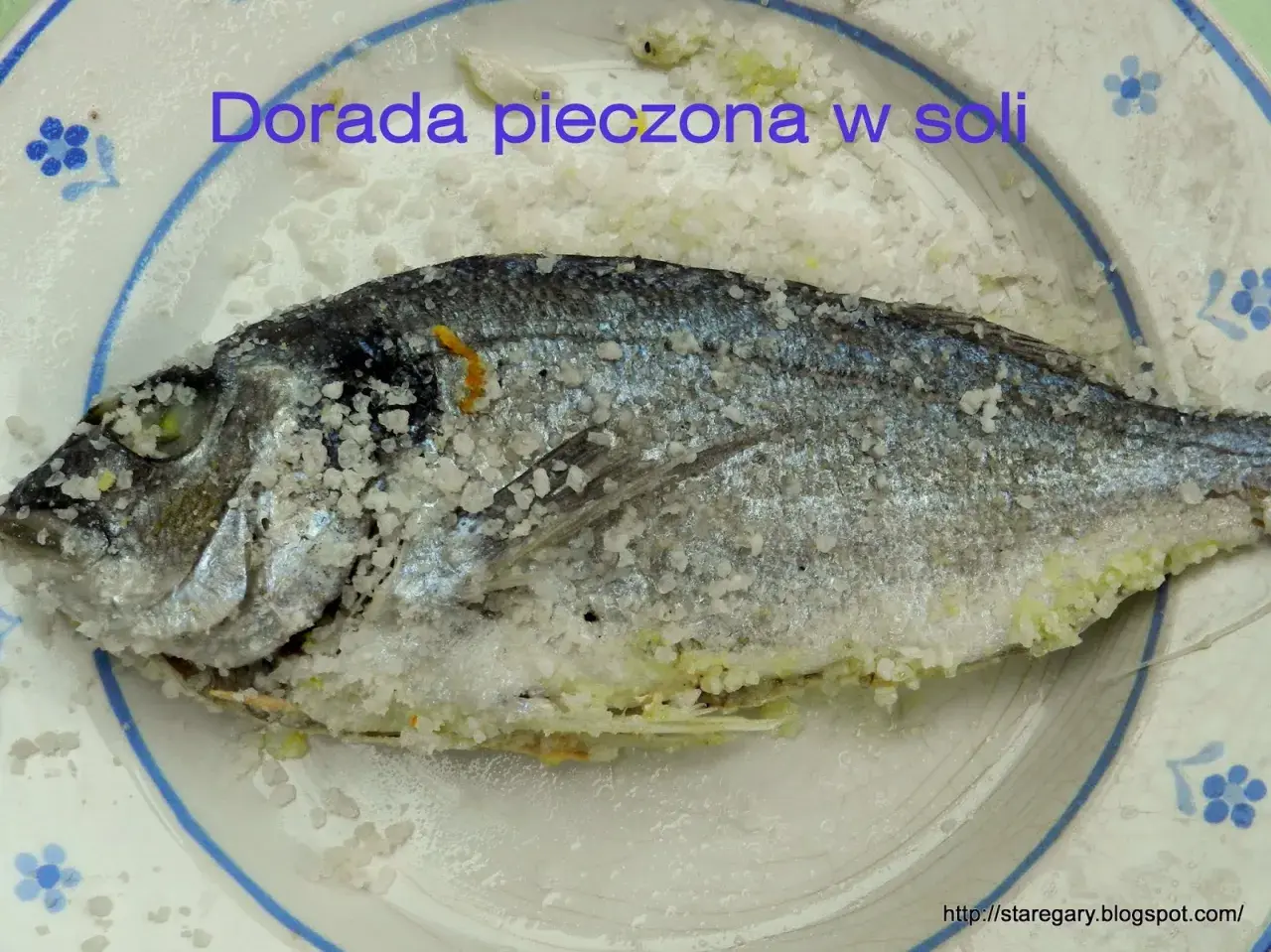 Dorada pieczona w soli, cała ryba pokryta grubą warstwą soli, gotowa do pieczenia.
