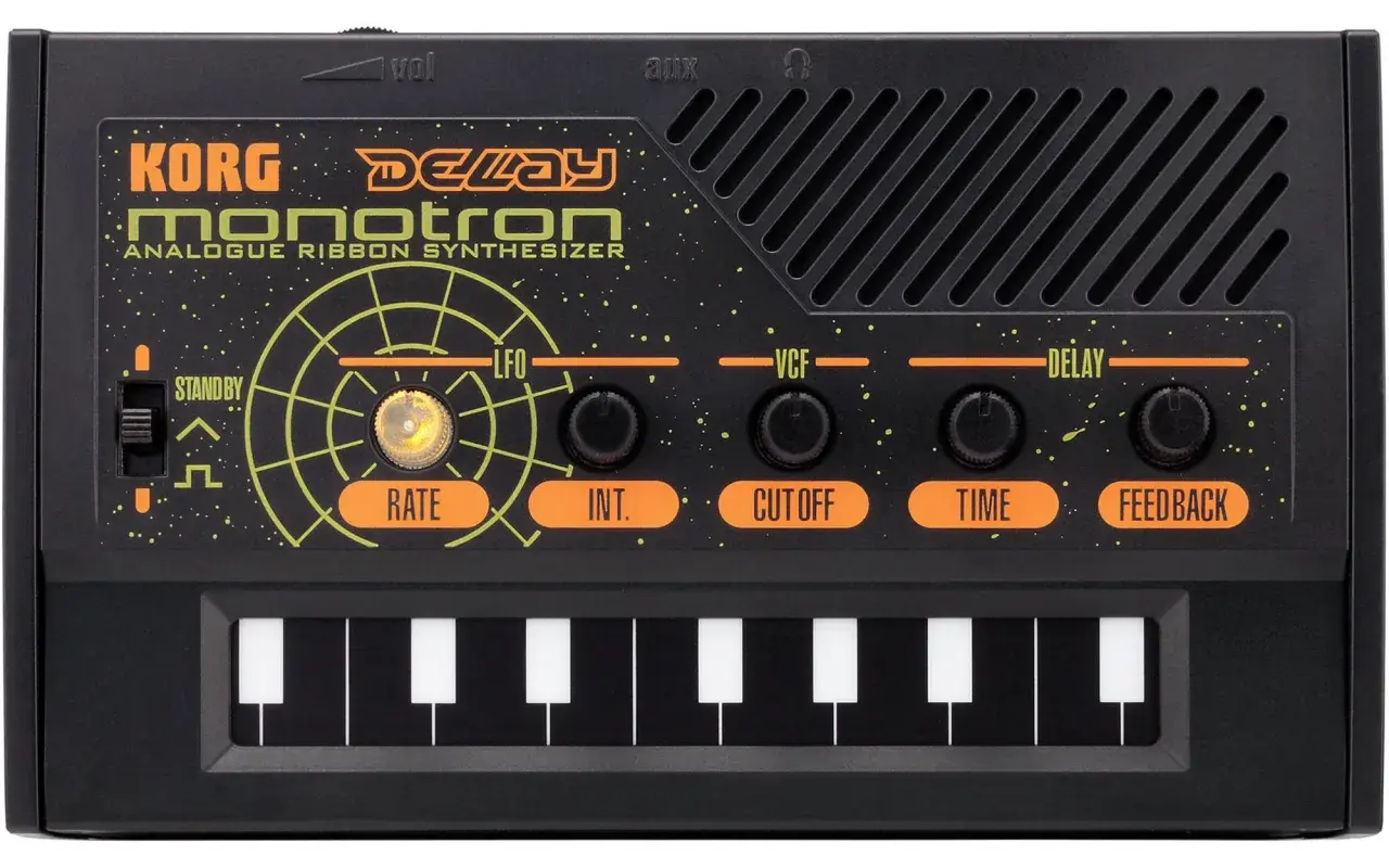 Korg Monotron Delay – co to jest syntezator? Czarny, analogowy syntezator z taśmą, klawiaturą i pokrętłami do kontroli dźwięku.