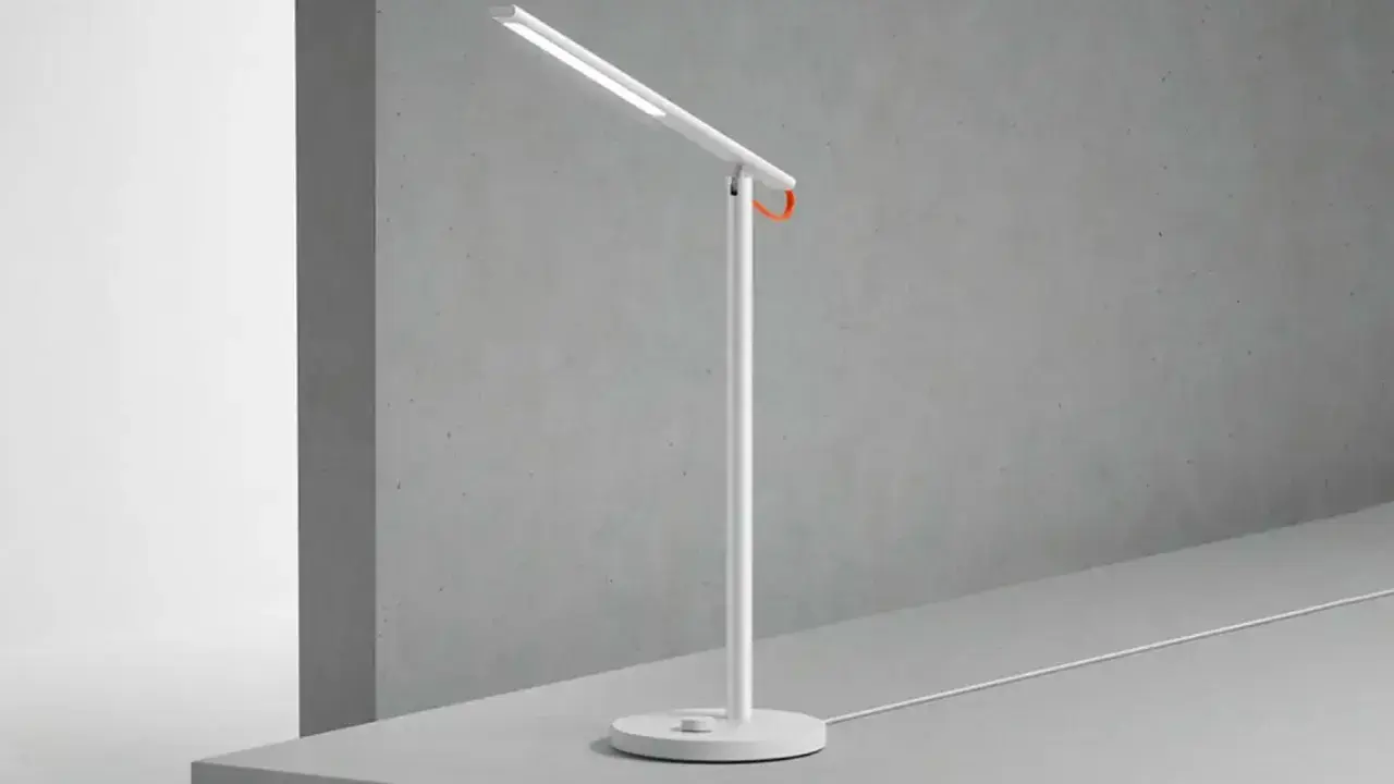 Un flexo vintage blanco con un toque naranja, ideal para iluminar tu espacio de trabajo con estilo.