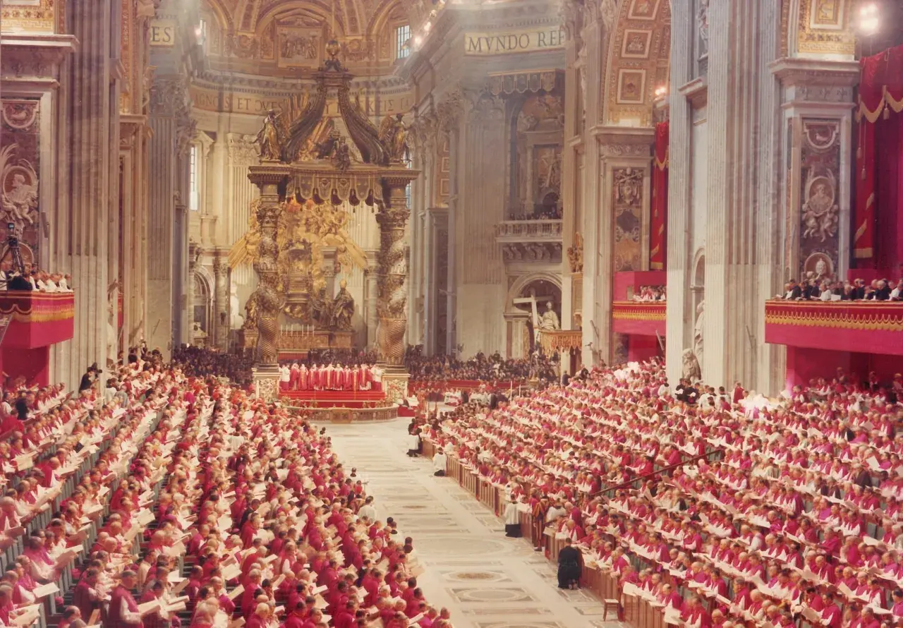 Große Versammlung von Geistlichen in roten Gewändern in einer prächtigen Kirche. Die Bedeutung einer Synode wird hier durch die schiere Anzahl der Teilnehmer und die feierliche Atmosphäre deutlich.
