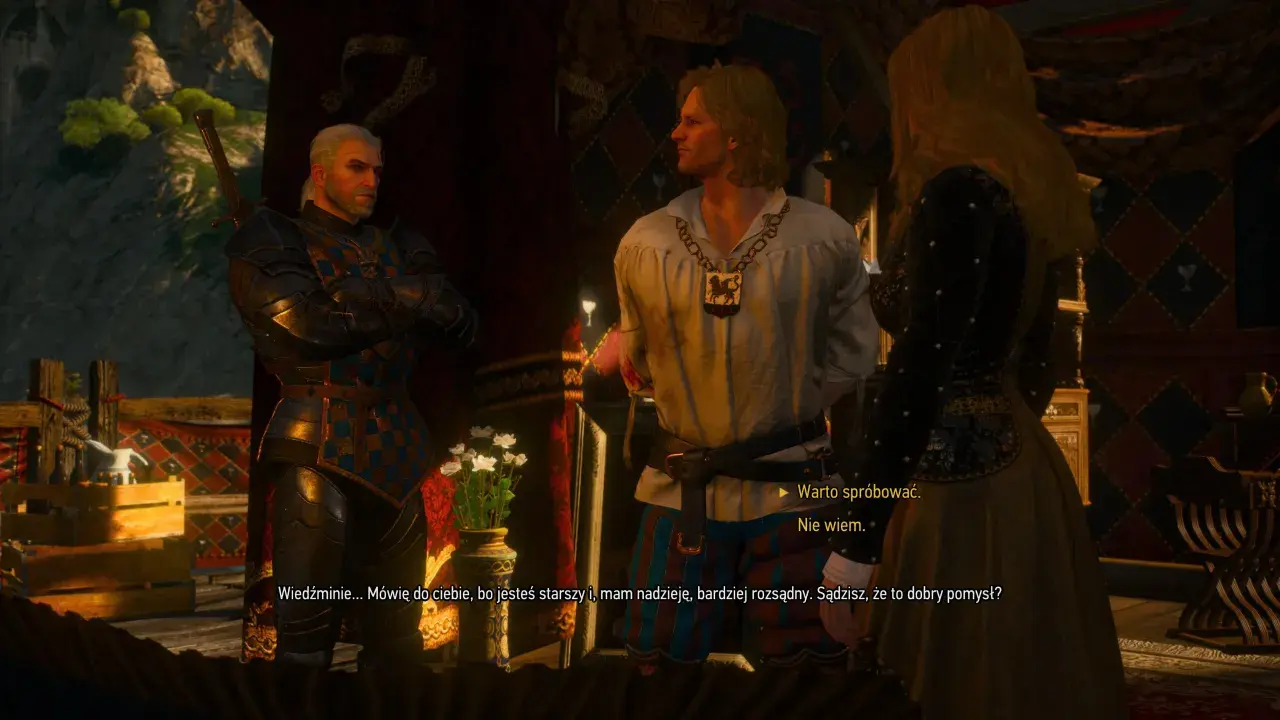 Geralt z Rivii w zbroi rozmawia z młodym mężczyzną i kobietą. W tle widać wnętrze karczmy w Wiedźmin 3.